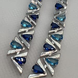 Pendientes largos con circonitas de color azul rodiados en oro blanco