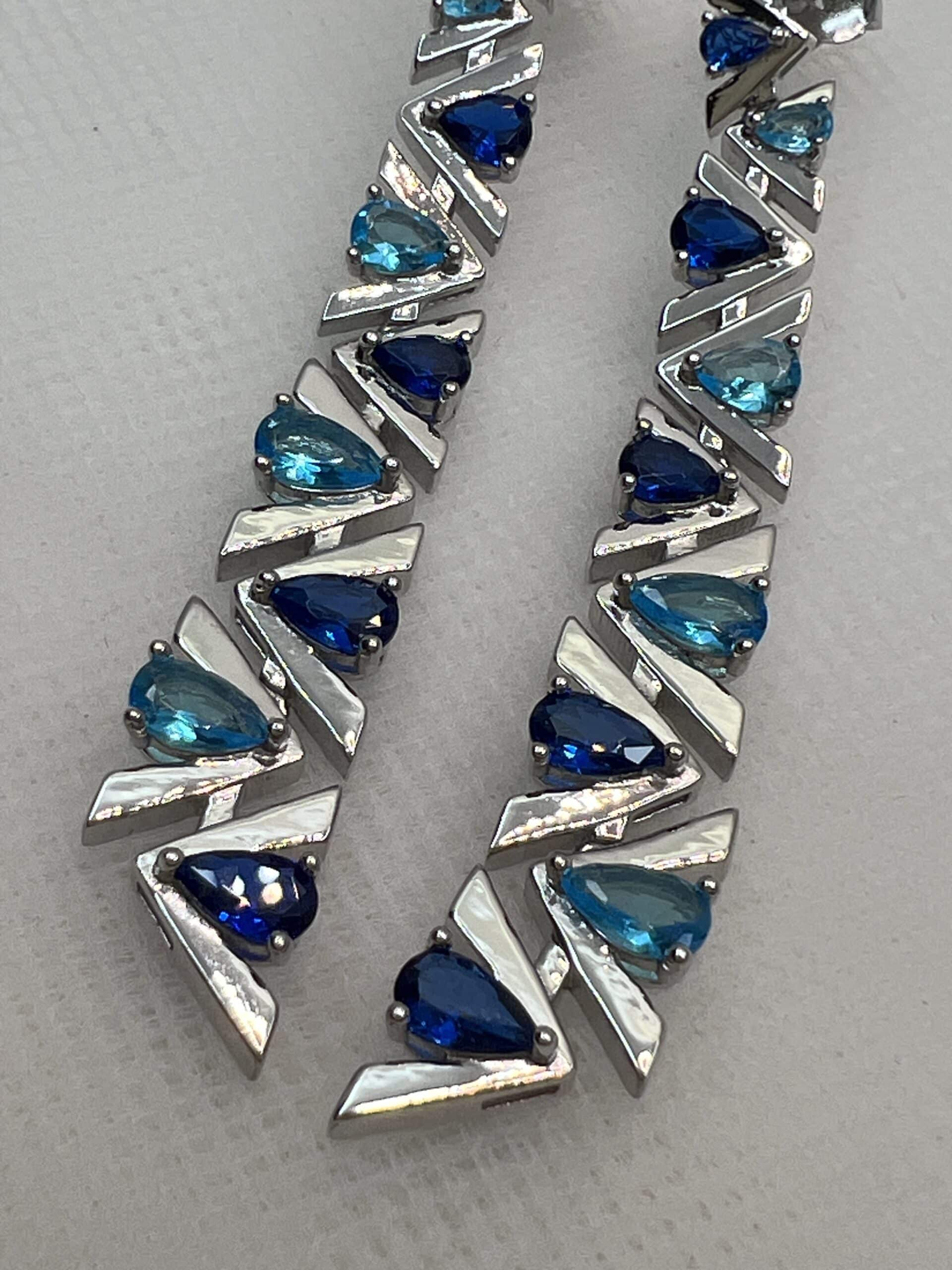 Pendientes largos con circonitas de color azul rodiados en oro blanco