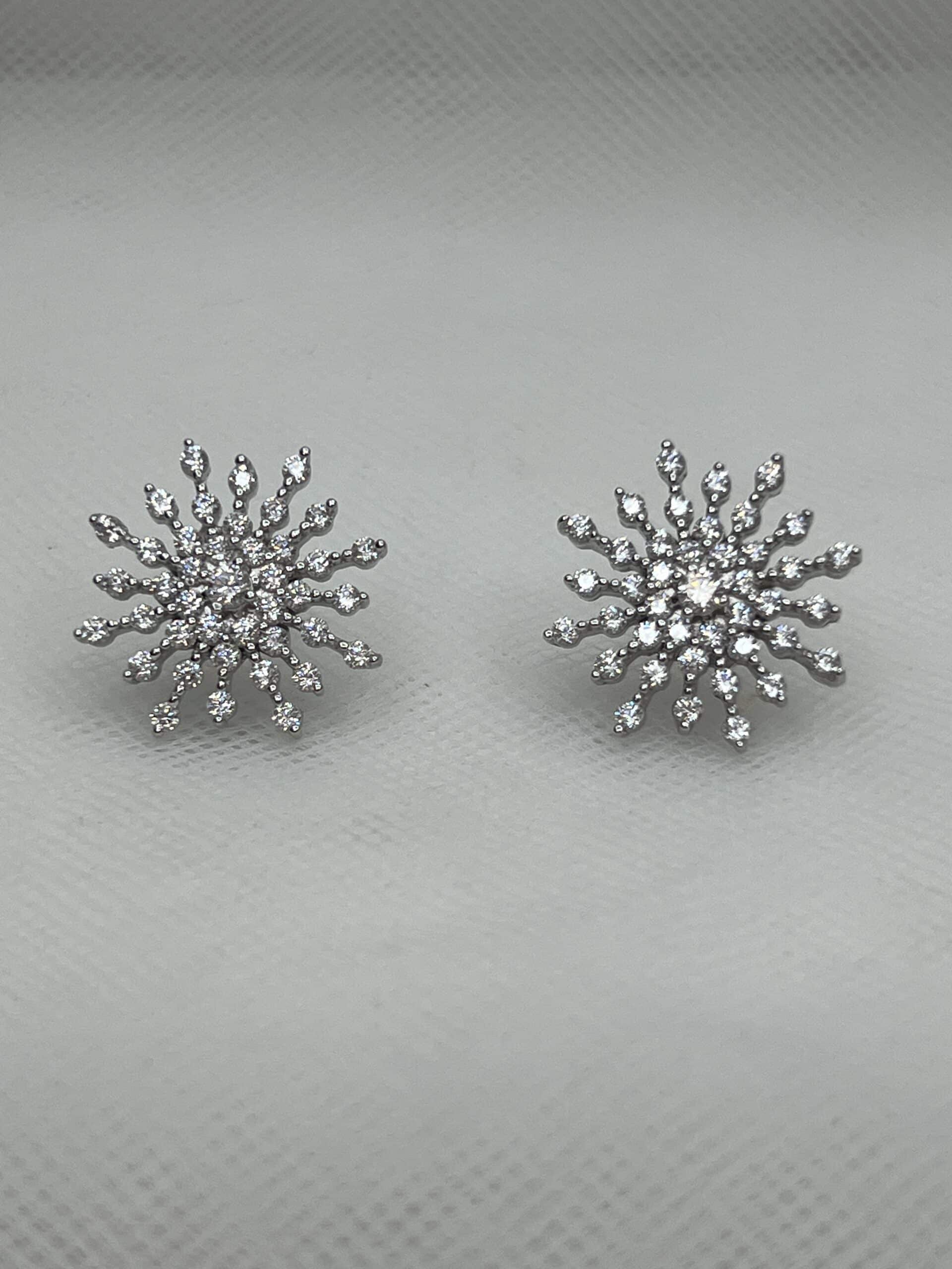 Pendientes de botón con forma de copo de nieve con circonitas rodiado en oro blanco.