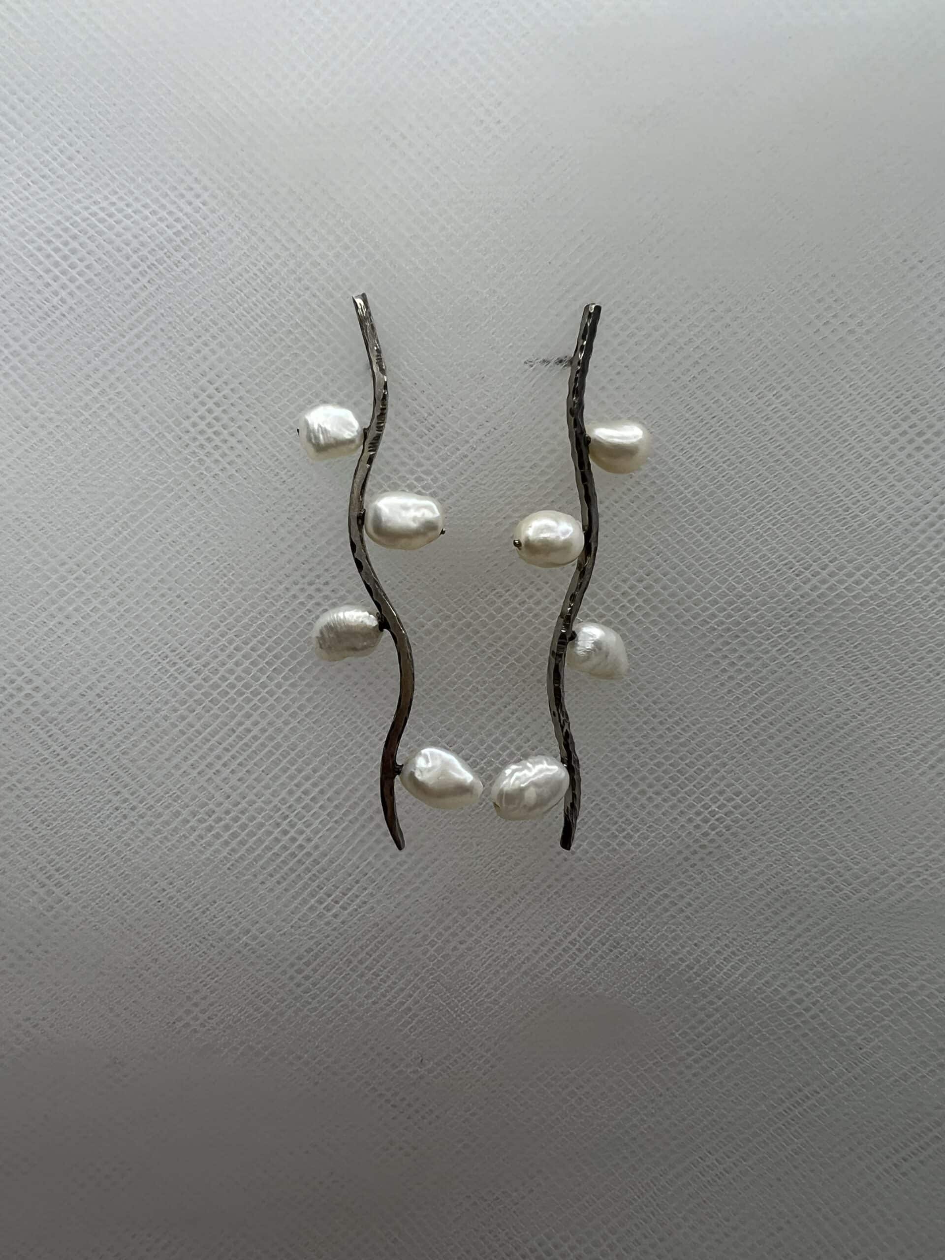 Pendientes largos de plata rodiados en oro blanco con perlas naturales.