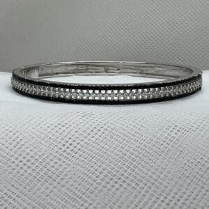 Esclava de plata con circonitas blancas y negras rodidada en oro blanco