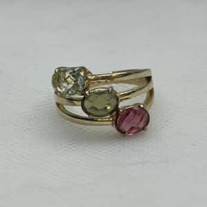 Tres anillos unidos chapados en oro amarillo con circonitas de colores.