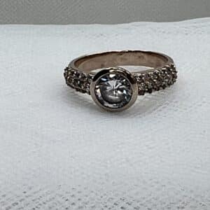 Solitario chapado en oro rosa con pave de circonitas y circornita central.