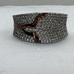 Anillo de plata rodiado en oro blanco con adorno en oro amarillo y pave de circonitas.