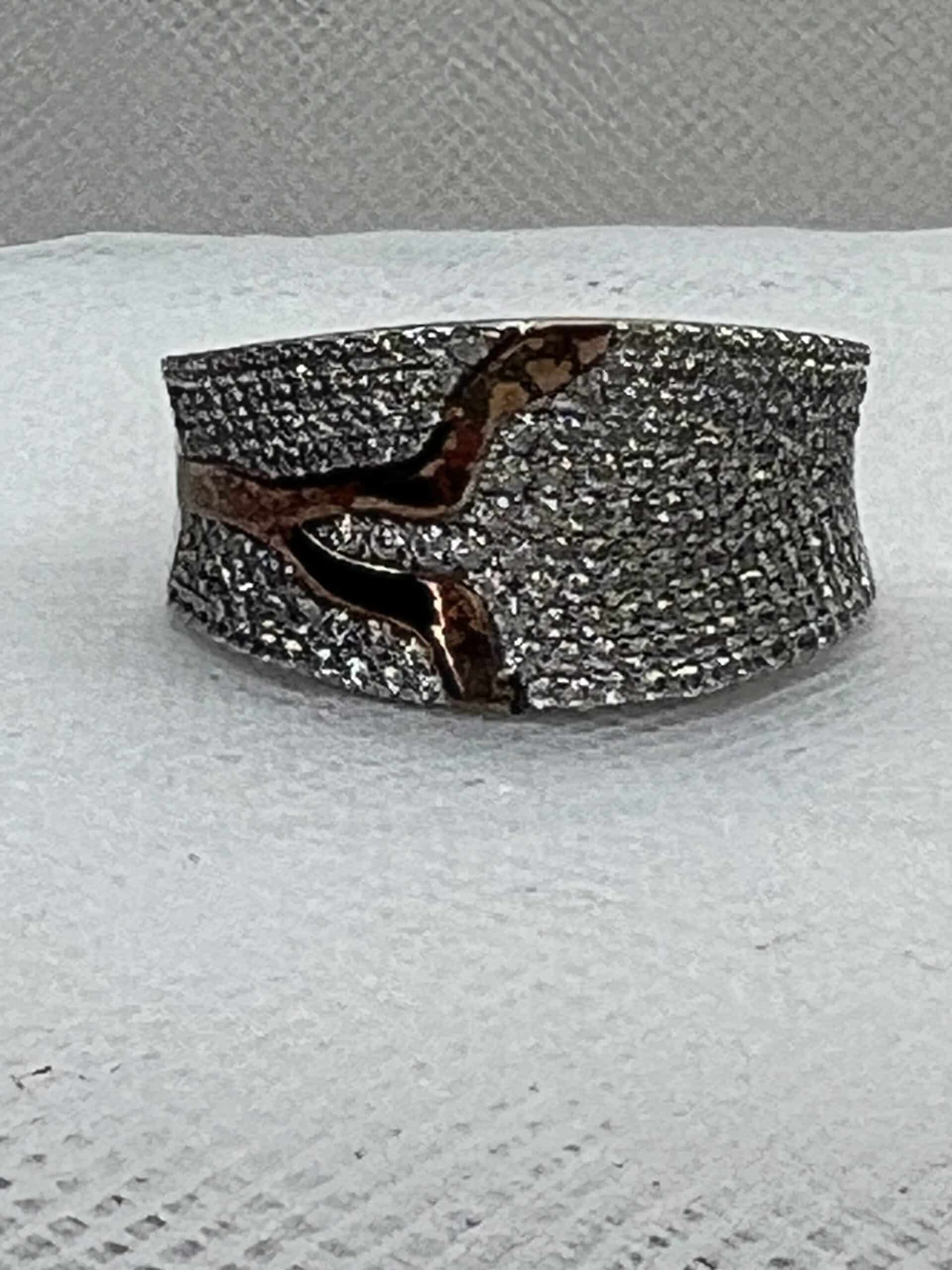 Anillo de plata rodiado en oro blanco con adorno en oro amarillo y pave de circonitas.