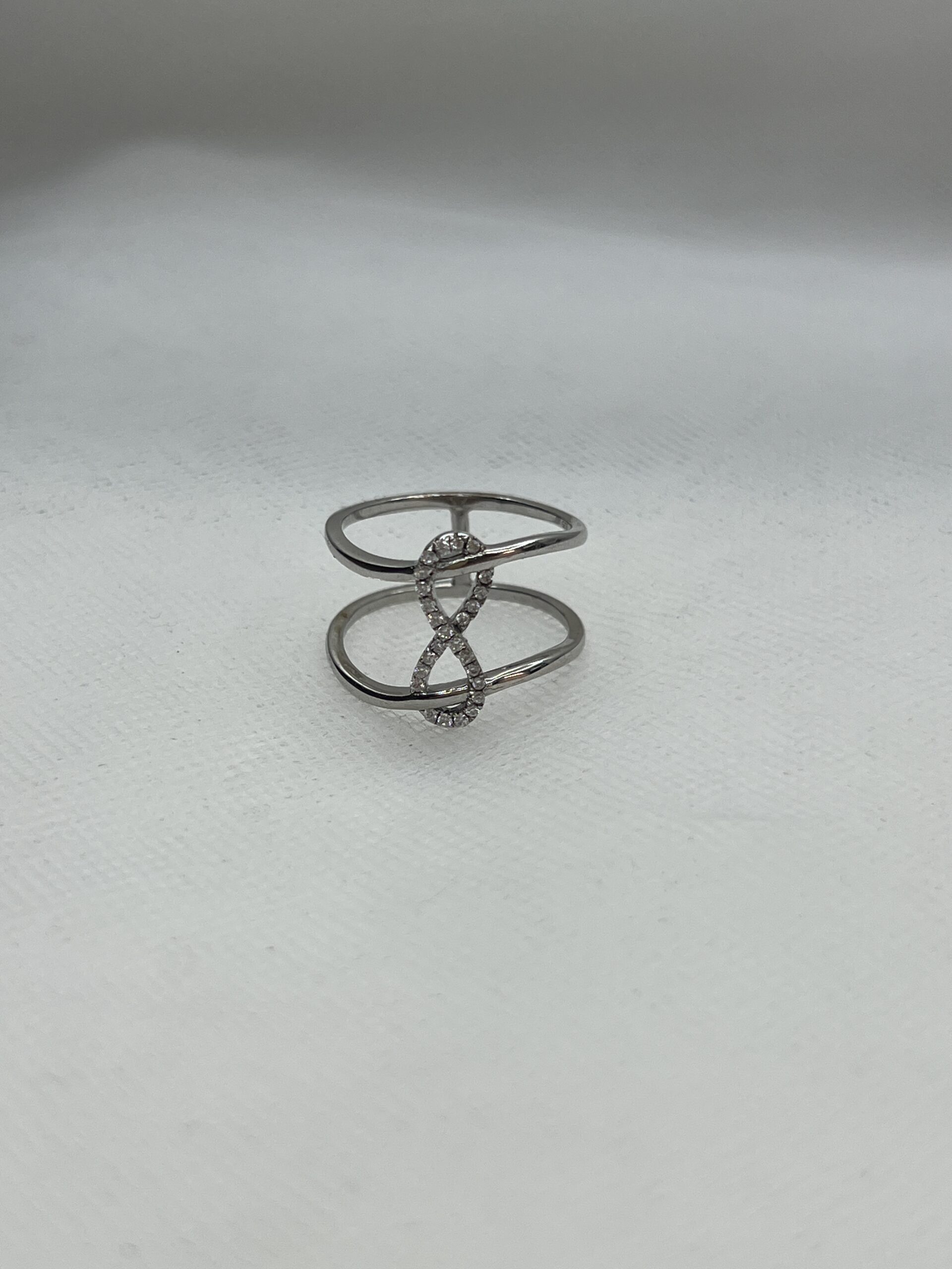 Anillo de plata rodiado en oro blanco con simbolo de infinito de circonitas.
