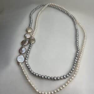 Collar de perlas blancas y grises naturales.