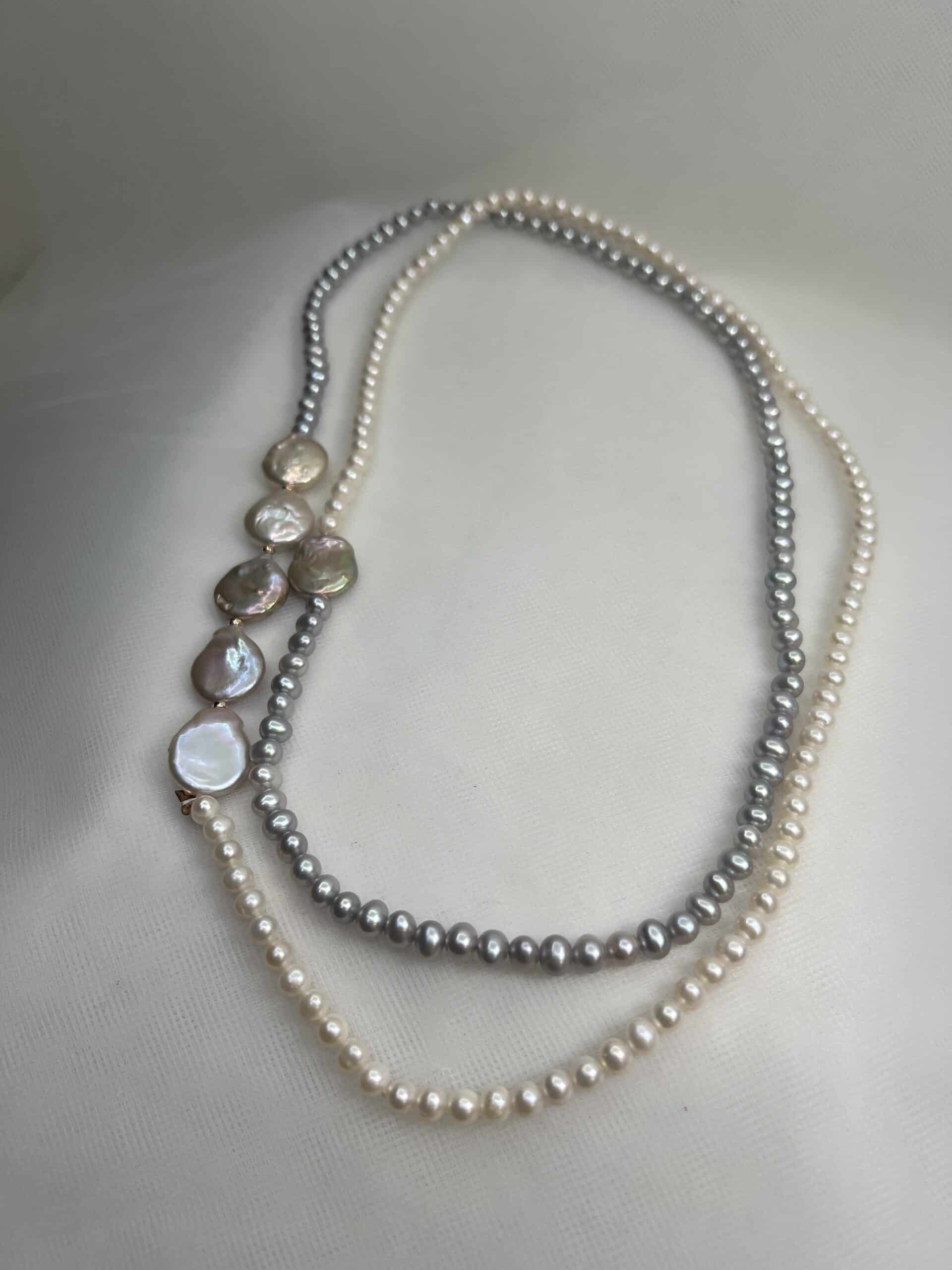 Collar de perlas blancas y grises naturales.