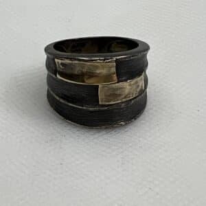 Anillo plata negra con oro amarillo.