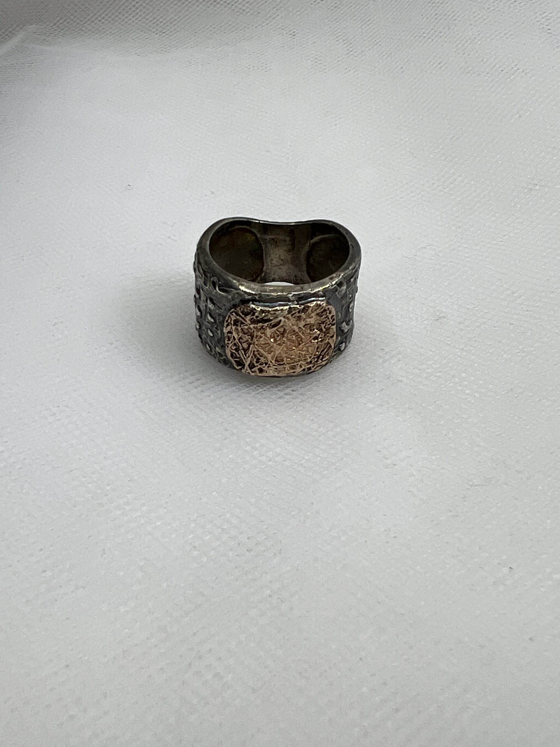 Anillo de plata negra con oro rosa.