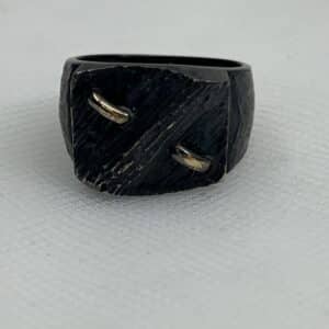 Anillo de plata negra con motivos de oro amarillo.