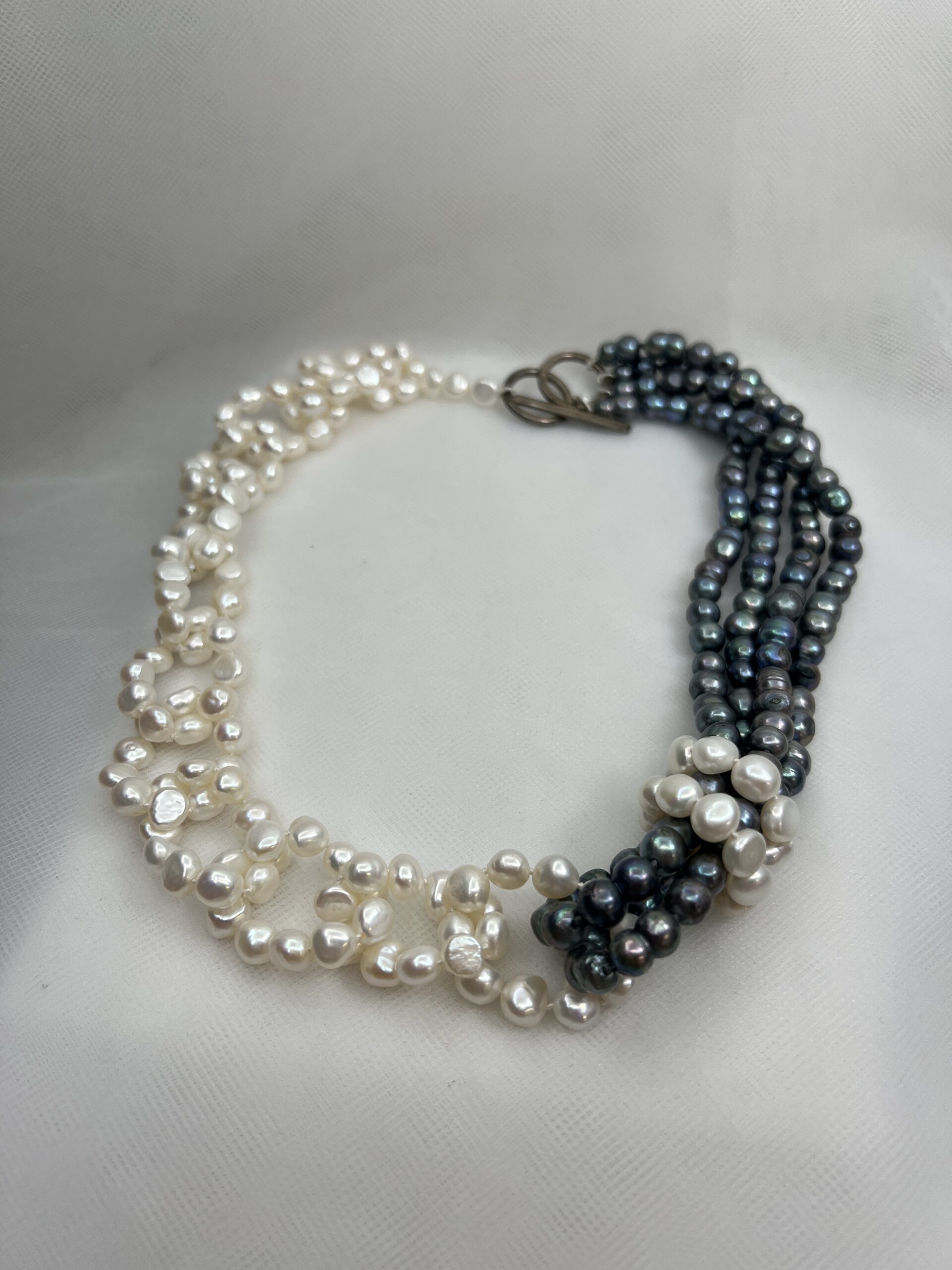 Collar de perlas naturales blancas y gris azulado.