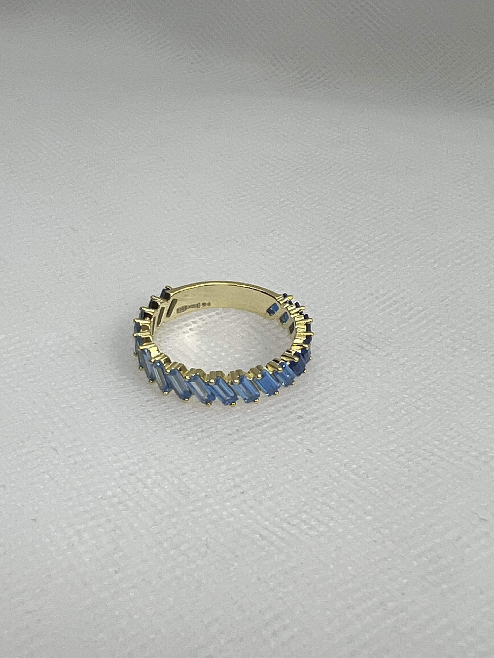 Anillo de plata chapado en oro amarillo con circonitas de tonos azules.