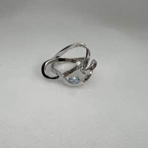 Anillo de plata rodiado en oro blanco con circonita de color azul.