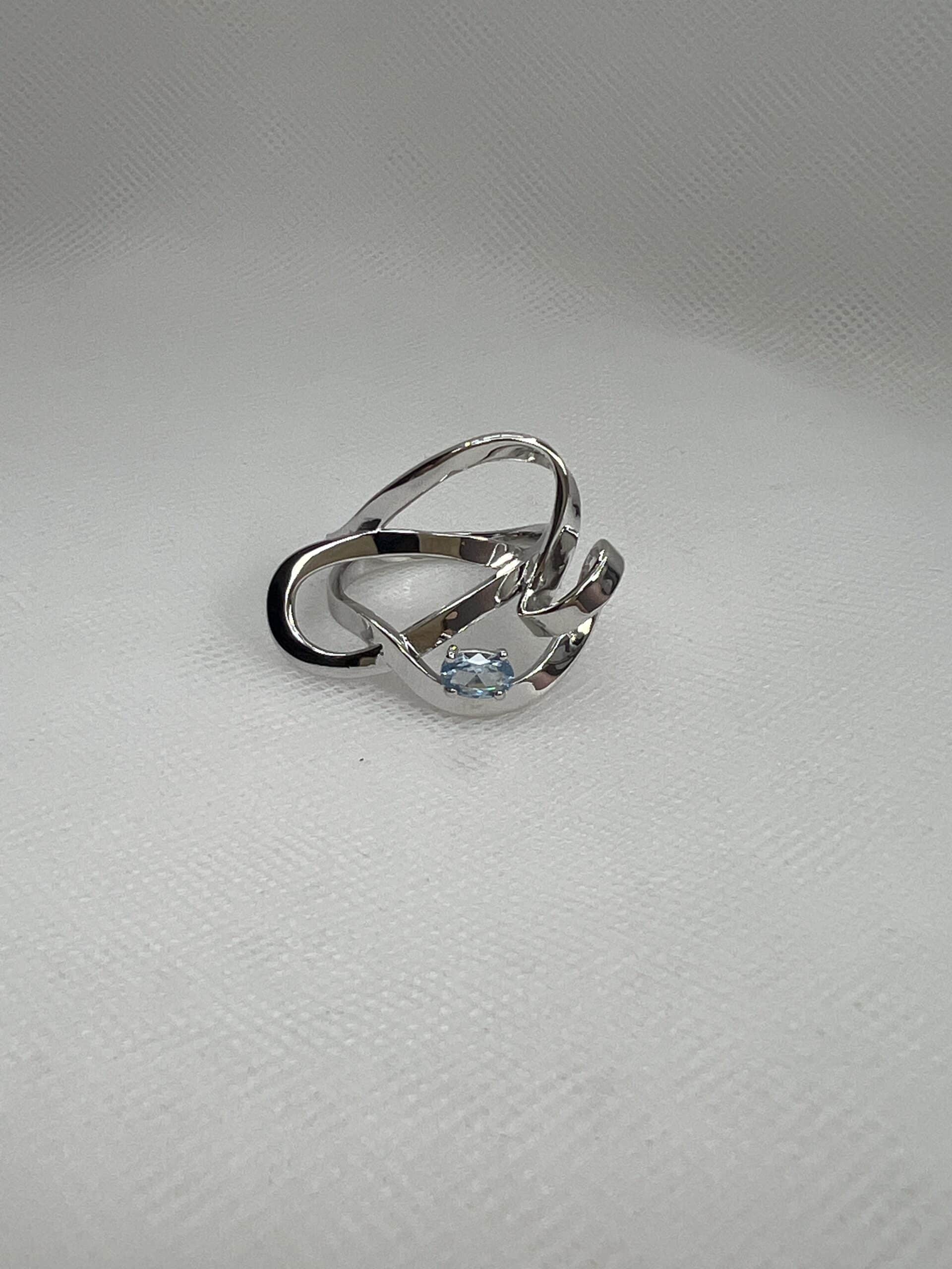 Anillo de plata rodiado en oro blanco con circonita de color azul.