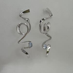 Pendientes largos de plata rodiados en oro blanco con circonita de color azul.