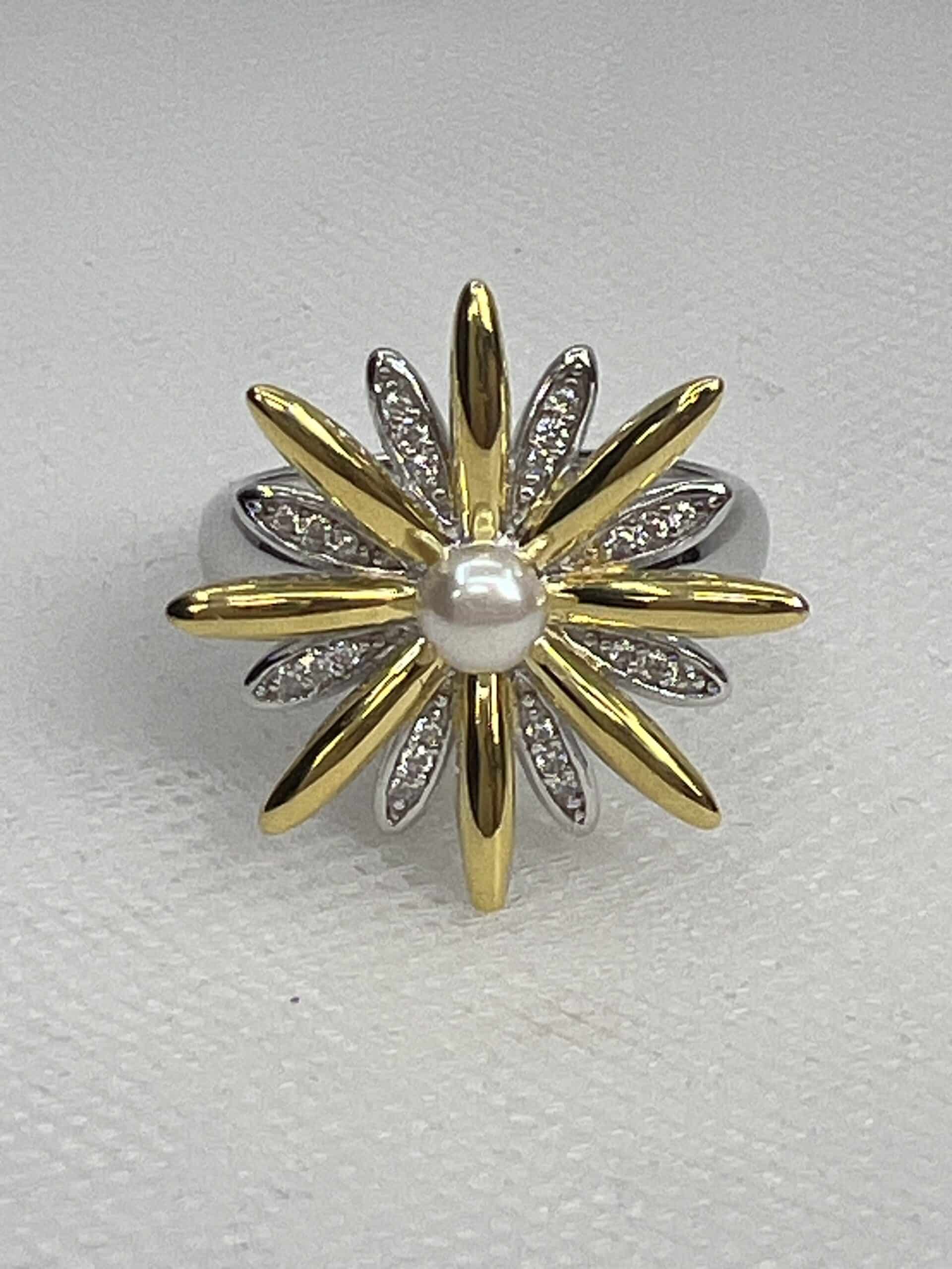 Anillo de plata rodiado en oro blanco y chapado en oro amarillo con forma de flor adornado con perla natural y circonitas.
