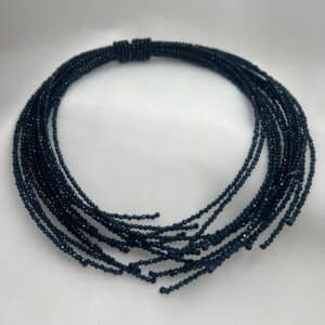 Collar de piedras de cristal de color azul semirigido abierto por el centro.