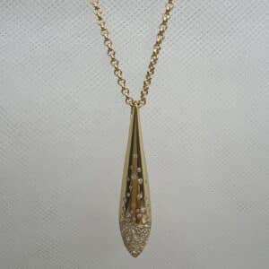 Collar de plata chapado en oro amarillo cadena de rolon con colgante alargado con circonitas engastadas de distinto tamaño.