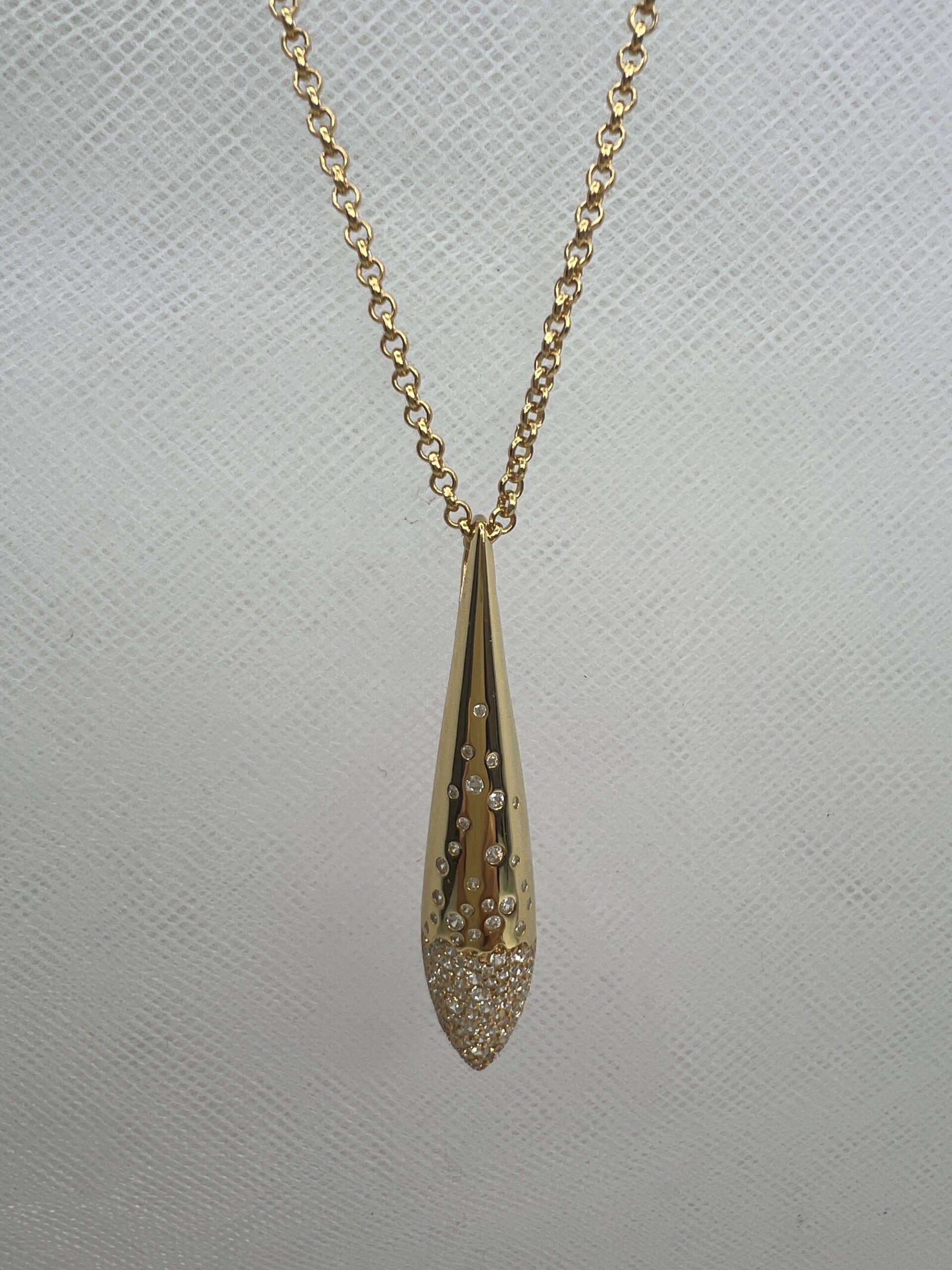 Collar de plata chapado en oro amarillo cadena de rolon con colgante alargado con circonitas engastadas de distinto tamaño.