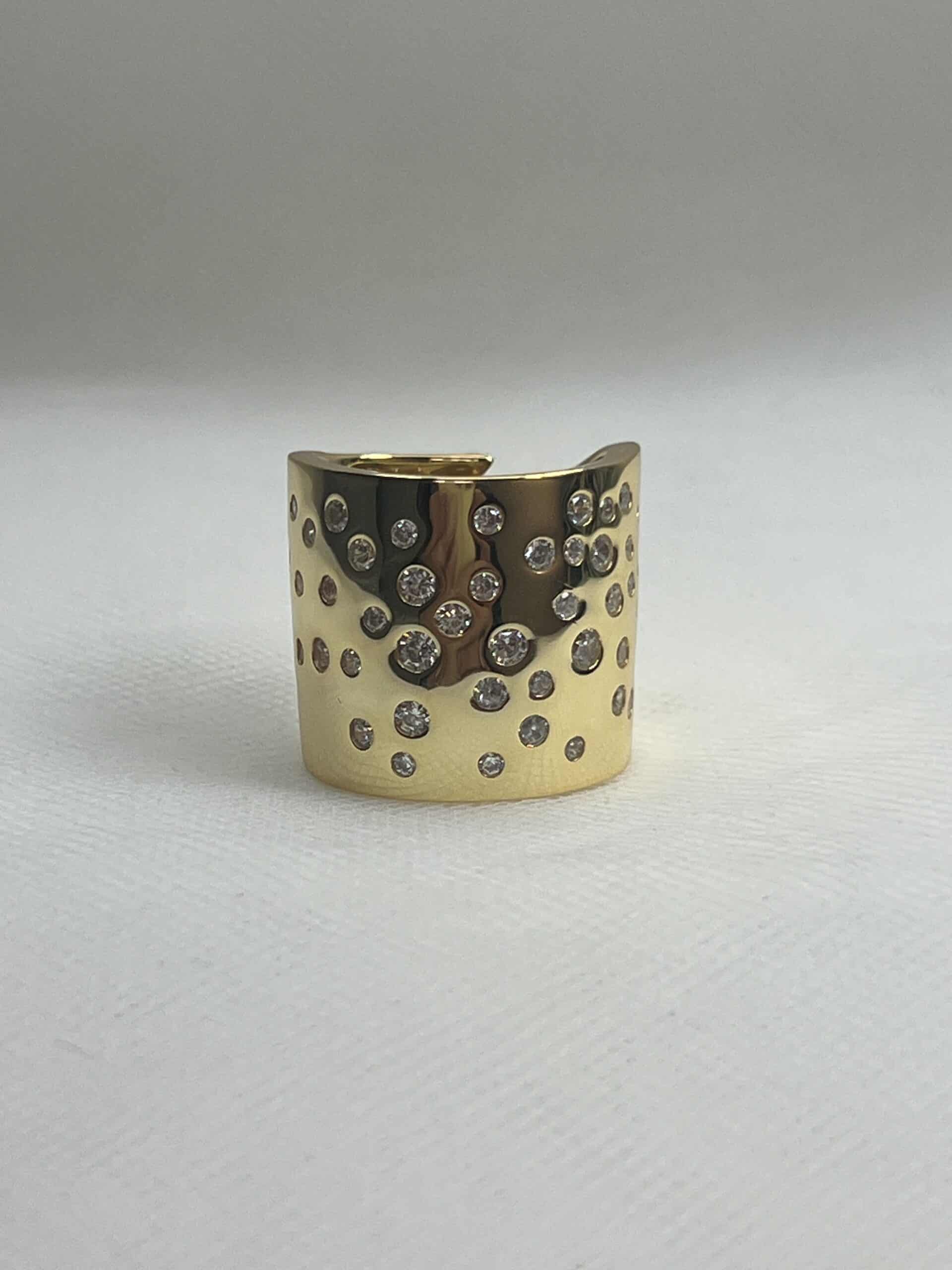 Anillo XL de plata  chapado en oro amarillo brazo ancho ajustable con circonitas engastadas de distintos tamaños.
