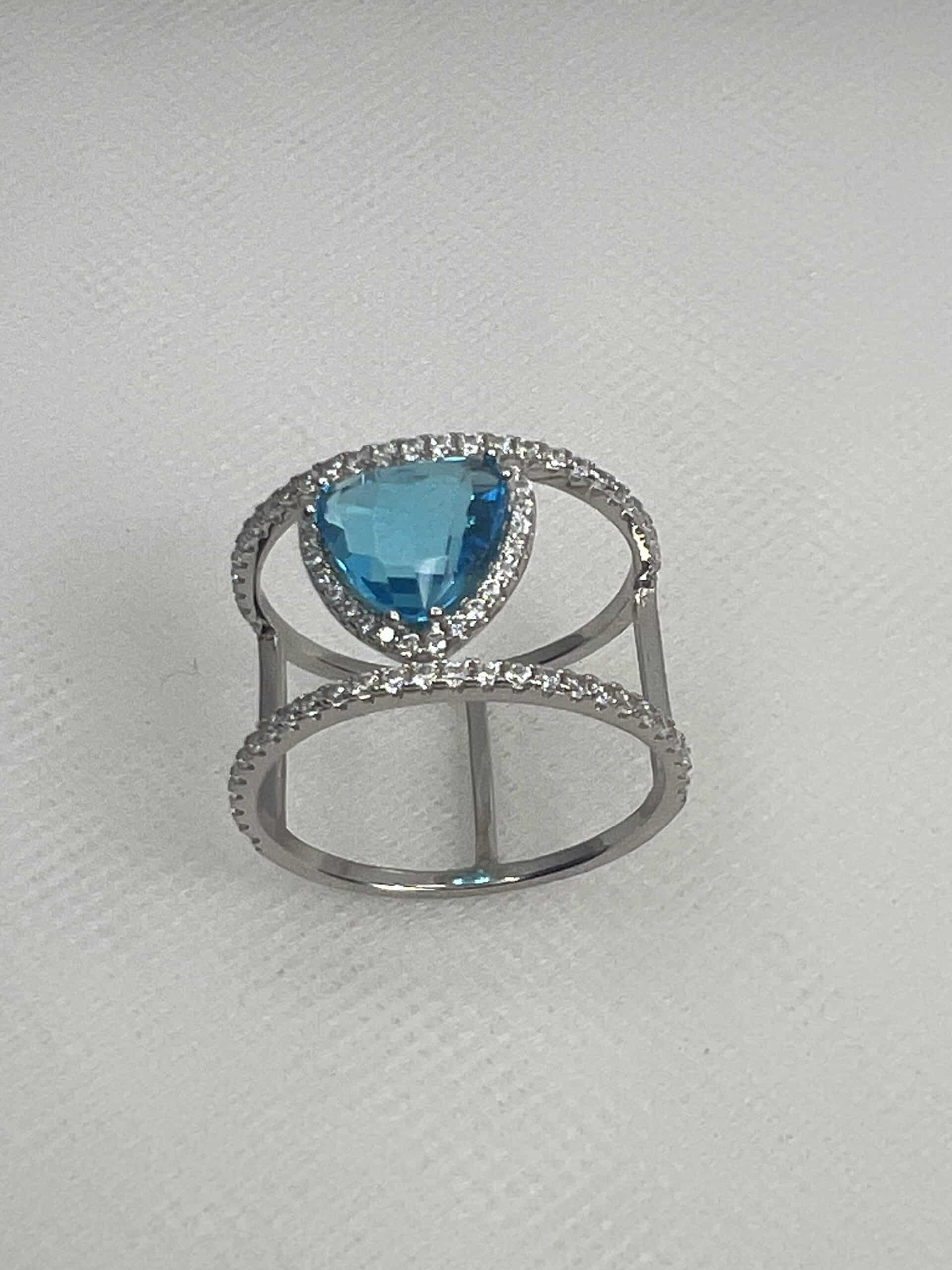 Anillo de plata rodiado en oro blanco con circonitas y circonita azul.