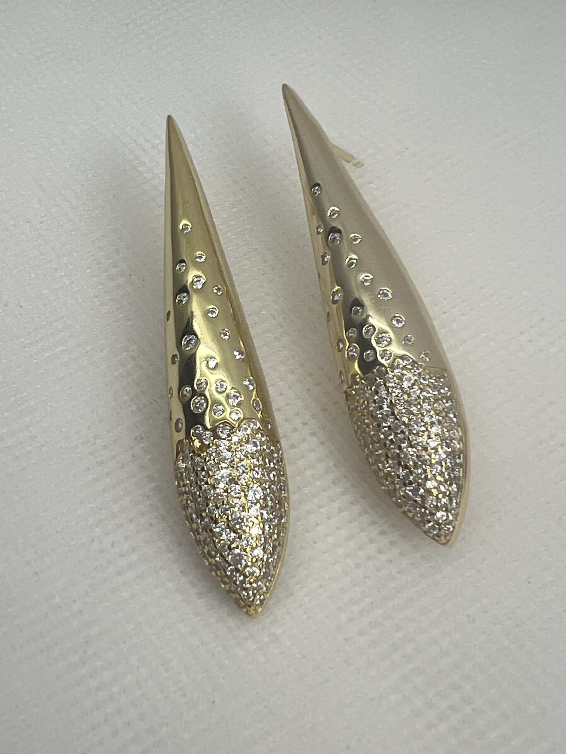 Pendientes largos de plata chapados en oro amarillo gotas alargadas con circonitas engastadas de distintos tamaños.