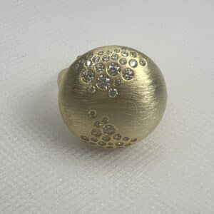 Anillo de plata chapado en oro amarillo media bola matizada con circonitas de varios tamaños engastadas