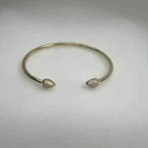 Esclava de plata chapada en oro amarillo abierta en el centro con terminacion en forma de gota con circonitas.