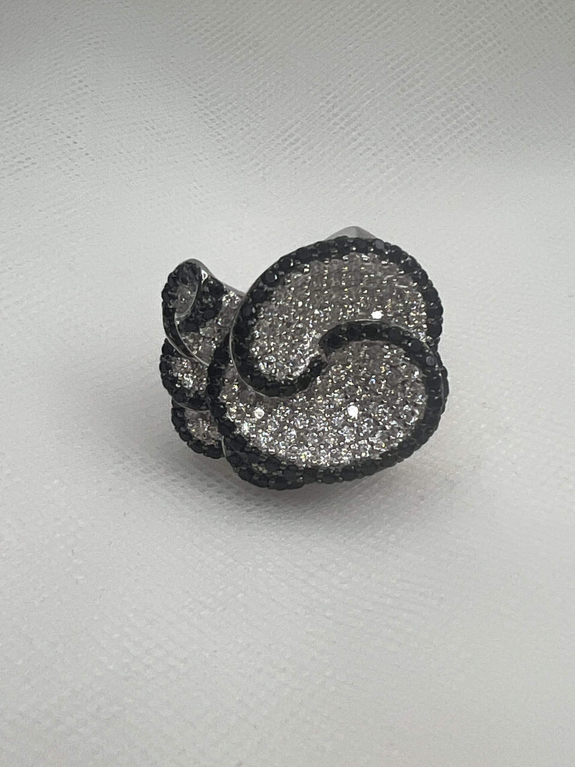 Anillo de plata rodiado en oro blanco forma de flor con circonitas blancas y marquesitas negras.