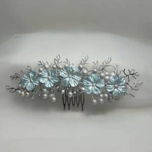 Tocado de flores de porcelana y ramitas de metal plateado.
