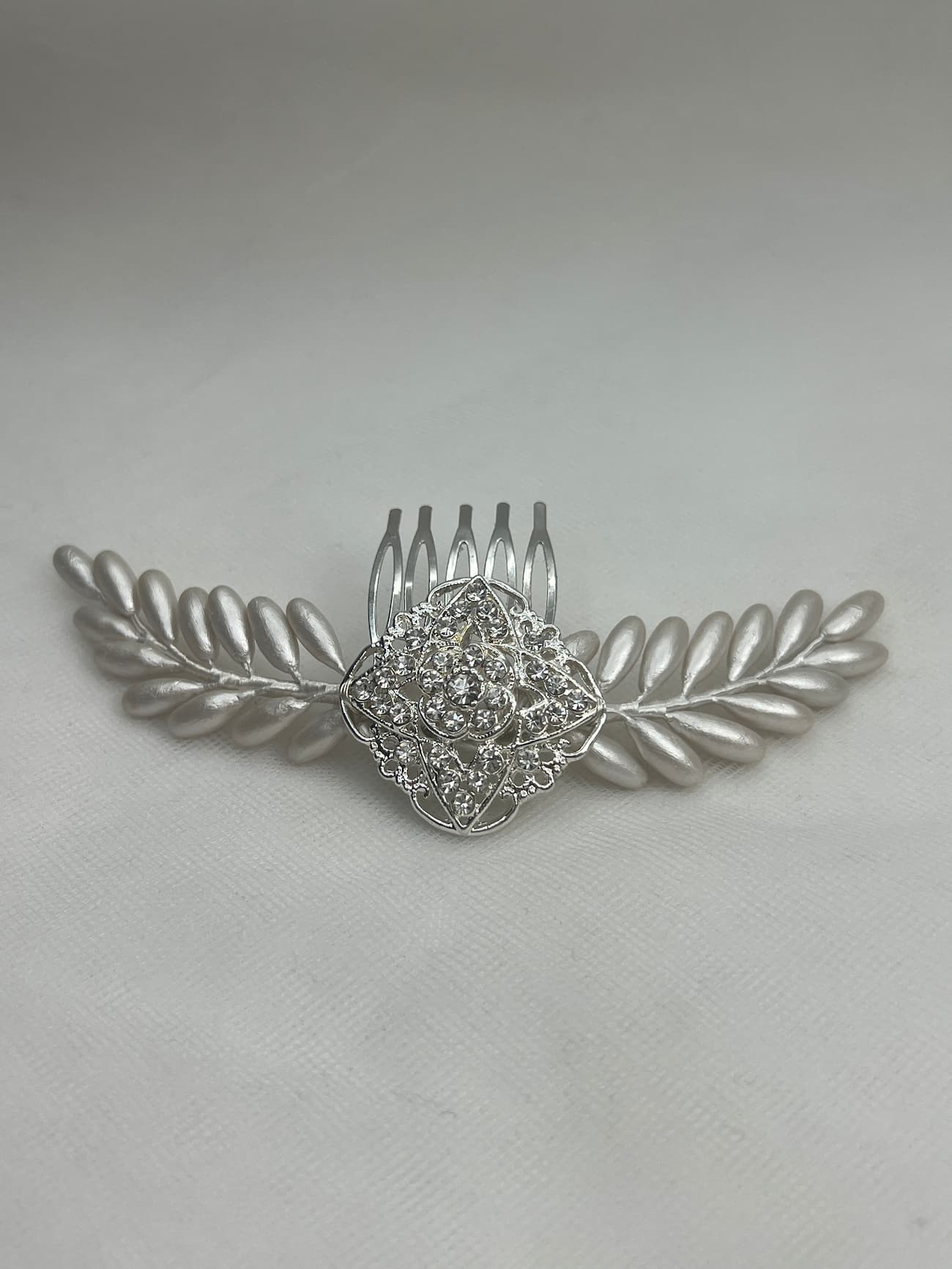 tocado de brotes de porcelana y broche plateado con strass